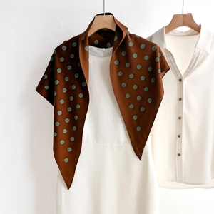 Brown polka dot silk scarf with vintage green pattern styled as a neck wrap on white dress
