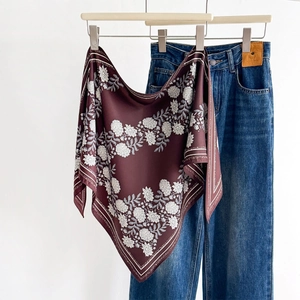 Elegant vintage floral silk scarf in burgundy with white patterns on a clothes hanger