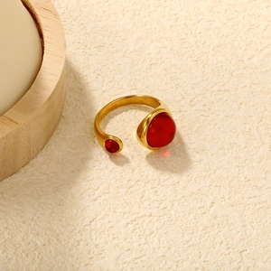Detail of gold-plated stainless steel open ring with two asymmetrical red stones