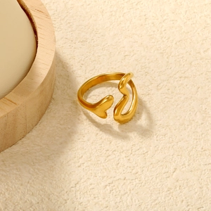 Macro view of 18K gold plated irregular open ring on a textured minimalist stone background