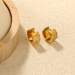 Close-up of golden hoop earrings featuring double-row inlaid white zircon stones