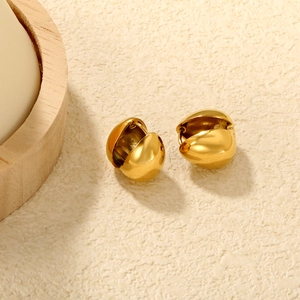 Detailed macro view of gold-plated chunky hoop earrings with a mirror-polished finish