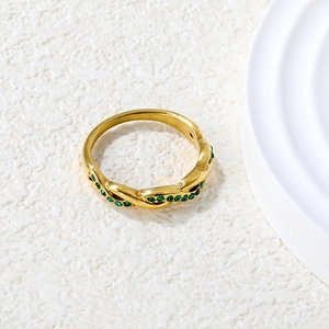 Detailed macro shot of vintage emerald pavé twisted gold ring on a stone texture