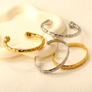 Set of four celestial cross open bangles with hammered texture and sun moon star engravings