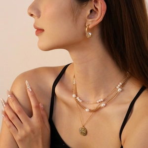 Detailed view of layered 18K gold plated chain necklace with a freshwater pearl and coin pendant