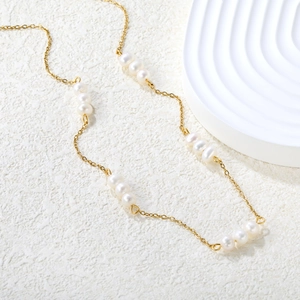 Macro detail of 18K gold plated chain with five groups of lustrous freshwater pearls