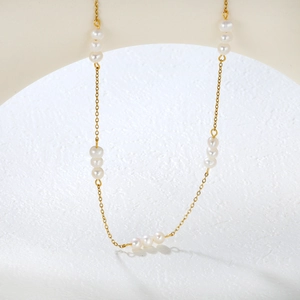 Detail of 18K gold plated stainless steel chain with dainty white freshwater pearls