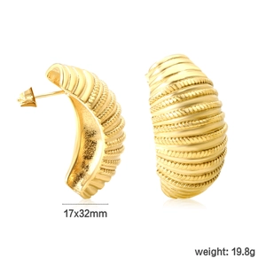 Détails de boucles d'oreilles créoles dorées avec motifs tissés et texture ondulée