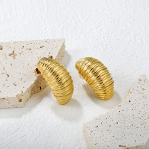 Vue détaillée des boucles d'oreilles dorées en forme de C avec texture vintage mate