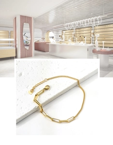 Detalle de tobillera de cadena bañada en oro de 18K con dije de corazón sobre piedra