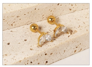 Detail of 18K gold-plated leaf stud earrings featuring marquise-cut white zircons and ball backs