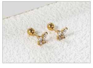 Vue macro de boucles d'oreilles papillon dorées avec zircone blanche et fermoir à vis