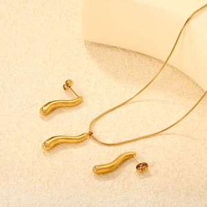 Minimalist gold plated jewelry set featuring streamlined wave necklace and matching earrings