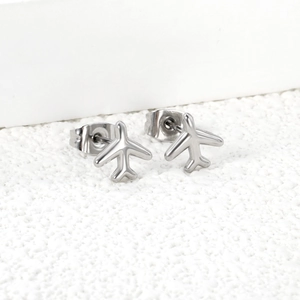 Gros plan de boucles d'oreilles avion minimalistes argentées avec finition polie miroir