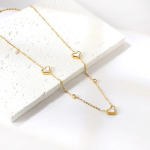 Macro view of gold heart necklace featuring white shell inlays and sparkling crystal accents