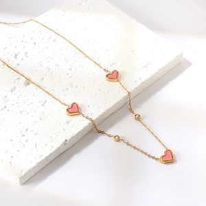 Elegant gold heart necklace with pink cat eye stones and small white zircons