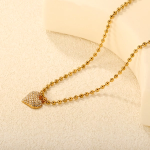 Elegant gold heart pendant necklace with shimmering pave zircons on a bead chain