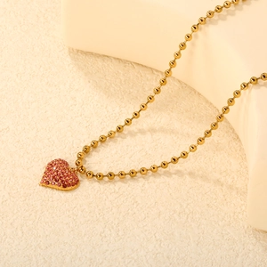 Elegant gold bead necklace featuring a heart pendant with sparkling pink crystals for women