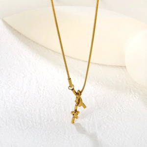Macro detail of golden knotted pendant with sleek snake chain in minimalist style