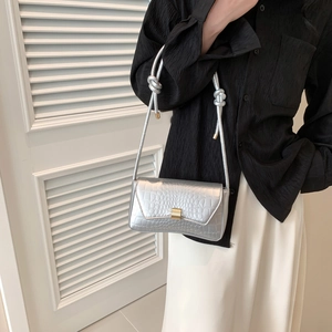 Borsa baguette argento effetto coccodrillo con fibbia dorata indossata da modella