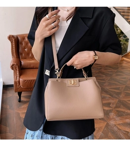 Détail du sac à main en cuir grainé marron clair avec son fermoir rotatif doré élégant