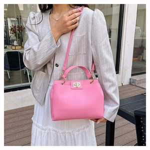 Sac à main rose en similicuir avec fermoir rotatif doré et texture grainée chic