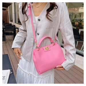Sac à main rose en cuir grainé avec fermoir doré et bandoulière réglable pratique