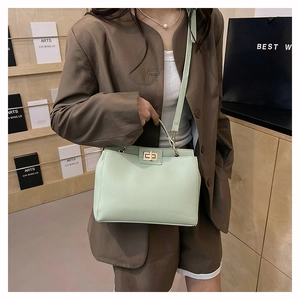 Détail du sac à main vert menthe avec motif litchi, fermoir doré et poignée supérieure