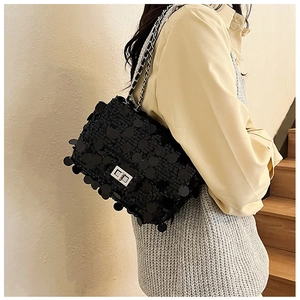 Detail of black sequin crossbody bag with silver chain strap and metallic clasp closure