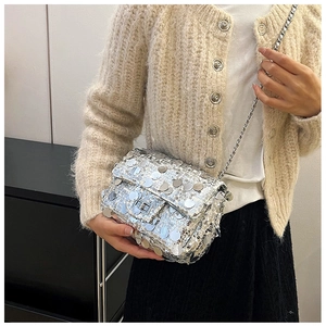 Detail of silver sequin crossbody bag with metal chain strap and turn-lock closure