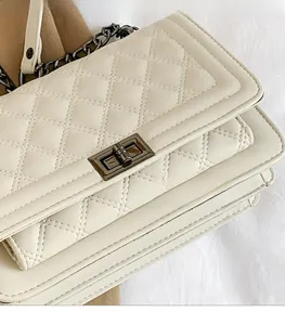 Detailed macro view of white quilted faux leather and vintage metal turn-lock closure