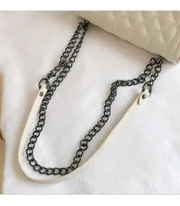 Detail of beige quilted faux leather bag with gunmetal chain and leather strap