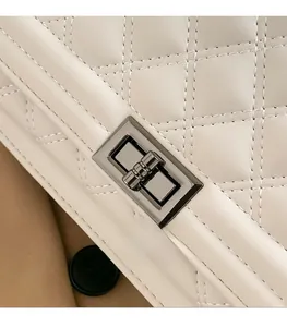 Detailed macro view of white quilted leather texture and silver metal twist lock closure