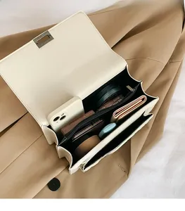 Detail view of the beige leather crossbody bag interior showing spacious compartments
