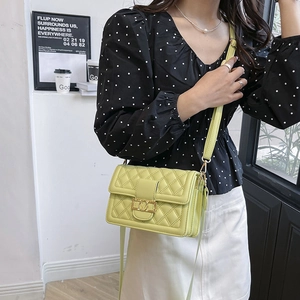 Elegante borsa a tracolla trapuntata verde lime con fibbia a V dorata su una modella
