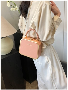 Pink octagonal box bag with gold frame and fashion text, shown in home setting