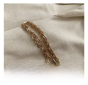 Close-up of elegant gold chain strap with classic links on textured fabric