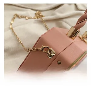Macro detail of high-quality golden chain hook and twisted handle on pink leather bag