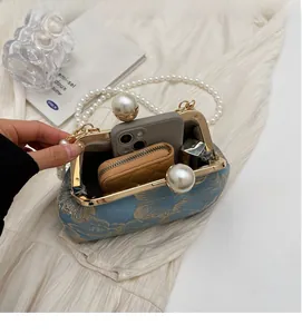 Detail shot of blue jacquard pearl clutch showing spacious interior for essentials