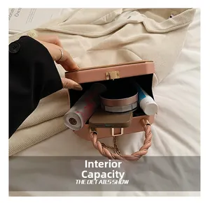 Detail view of pink box bag showing internal capacity for phone and cosmetics