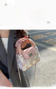 Detail of light pink quilted bucket bag with butterfly embroidery and chain strap