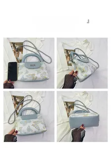 Detail of light blue quilted bucket bag with butterfly embroidery and silver chain strap