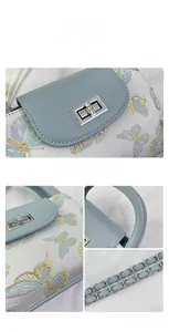 Detail of light blue bucket bag showing butterfly embroidery and silver rotary lock
