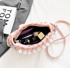 Detail van de roze geplooide cloud-tas met parelhandvat en afneembare schouderriem