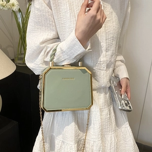 Elegant sage green box bag with gold metal trim and twisted handle for a stylish look