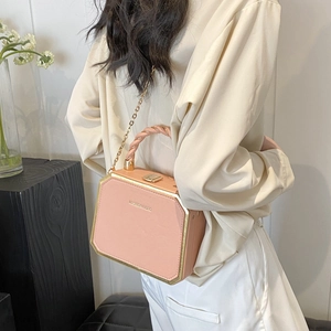 Pink twist-handle box bag with gold metal frame and chain strap shown on a model