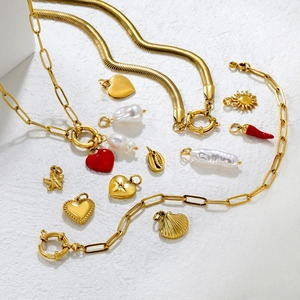 Gold stainless steel jewelry set with heart, starfish, and chili charms on white stone