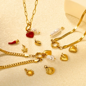Flat lay of 18K gold stainless steel charms with starfish and heart enamel details