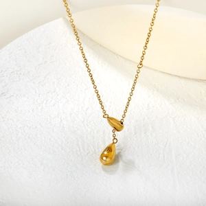 Macro shot of gold double teardrop pendants on a delicate chain necklace