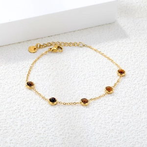 Detail of 18K gold stainless steel chain with round brown tiger eye gemstones